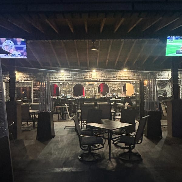 The Palazzo Ristorante's outdoor patio at night, with tables, chairs, and a bar area.