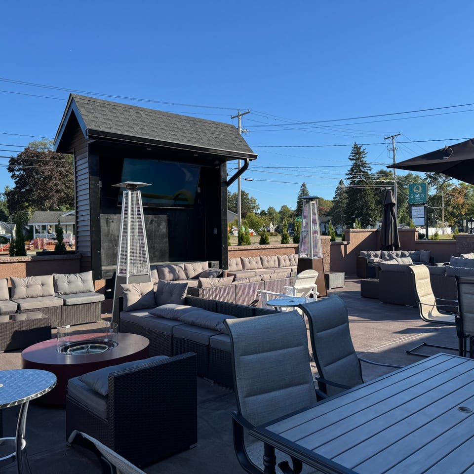 The Palazzo Ristorante's outdoor patio with lounge seating, fire pit, heaters, and a large TV screen.